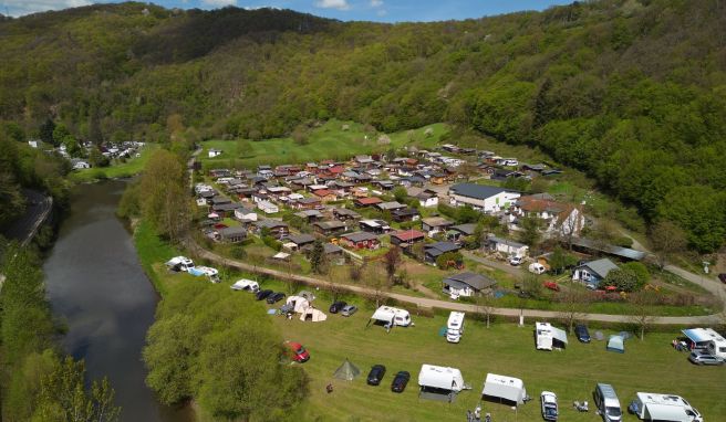 Zelte und Wohnmobile stehen auf dem Campingplatz Wiedhof am Ufer der Wied. Dahinter sind die Parzellen der Dauercamper zu sehen (Luftaufnahme mit einer Drohne).