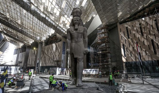 Arbeiter reinigen den Bereich neben einer riesigen Statue des ägyptischen Pharaos Ramses II. in der Halle des Großen Ägyptischen Museums. Elf Meter ist sie hoch.