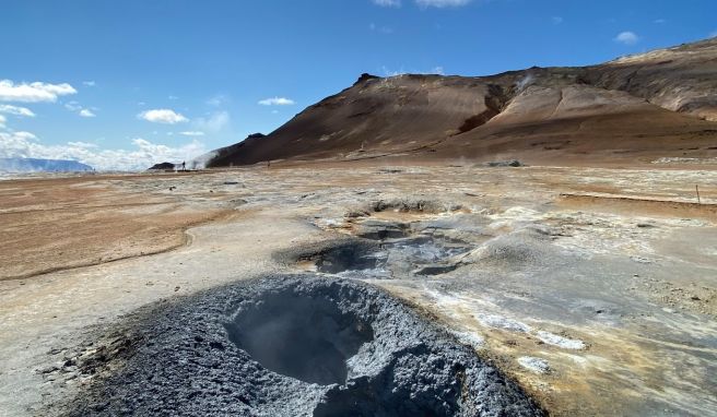 Im Geothermalgebiet Hverir blubbert und dampft es aus zahlreichen grauen Schlammlöchern.