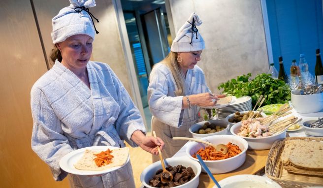 Kochbuchautorin Katariina Vuori (l) und die finnische Botschaftsrätin Tanja Huutonen belegen ihre Mittsommer-Wraps mit Lachs und Rentierfleisch.