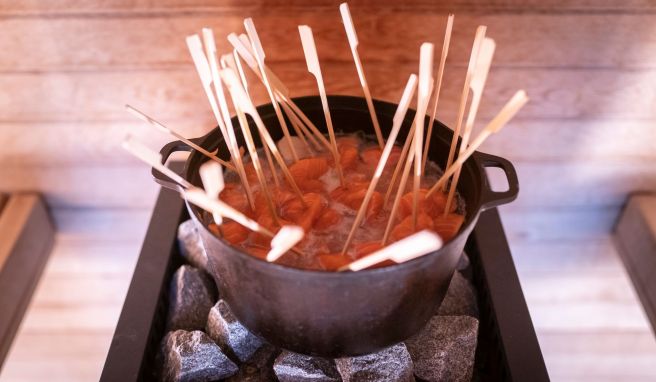 In einem Sud aus Weißwein, Wasser, Meerrettich, Dill, Sojasoße und Zitrone kocht der Lachs auf den Steinen des Saunaofens.