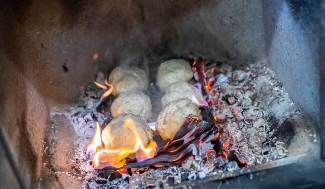 Auf einer Pappe kommen die Salzteig-Bällchen in die Glut.