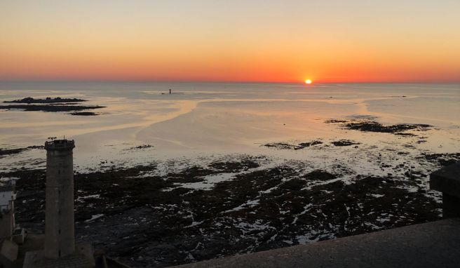 Bei Sonnenuntergang und ruhiger See gleicht die Küste vor dem Phare d\'Eckmühl einem friedlichen Meeresidyll.