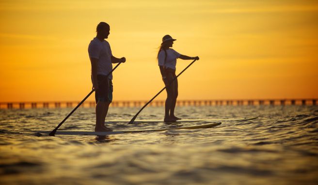 Balance halten: Wenn die See ruhig ist, lässt sich der Sonnenuntergang auf einem Stand-up-Paddle-Board genießen.