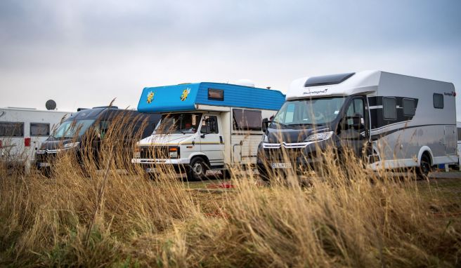 Wohnmobile stehen auf einem Parkplatz an der Nordseeküste.