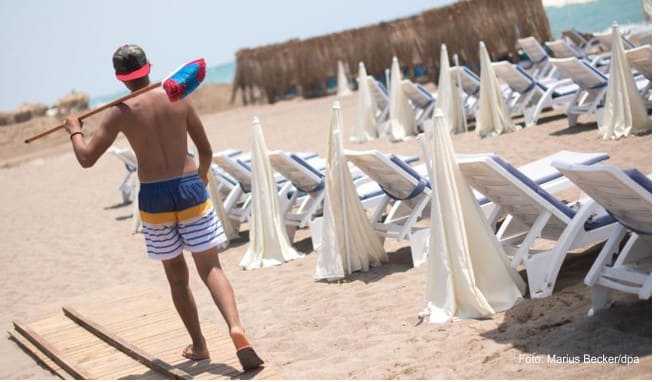 Ein Mann mit einem Besen geht an einem leeren Strand in Antalya entlang. Die Bundesregierung hat die Reisewarnung für die Türkei teilweise aufgehoben